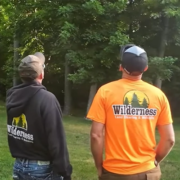 Two Wilderness Land Clearing workers looking at a tree.
