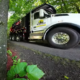 A Wilderness Land Clearing truck parked in a wooded driveway.